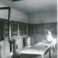 Interior of the coach-house of the Alexander Melville Bell's home across the street from the Volta Bureau. Coal stove near a table.