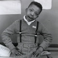 Photograph of a young African-American boy in a sweater and suspenders.