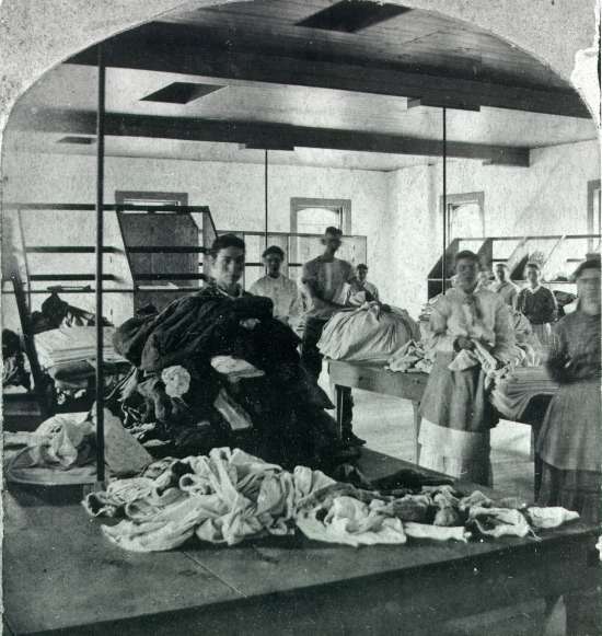 Stereo card of men and women at work in the laundry at Willard Asylym.