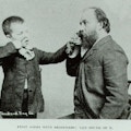 A teacher helps his young deaf student to recognize a sound placing the boys finger along side his nose.