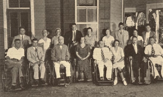 A group of seventeen people, some in wheelchairs, some standing.