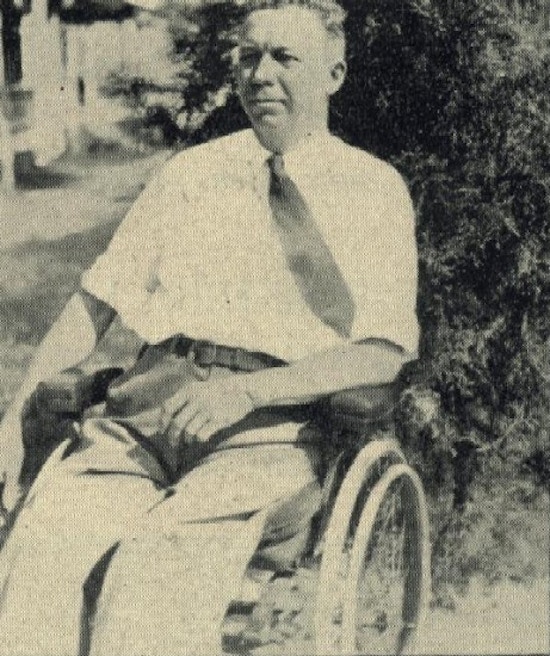 A middle-aged man sits in a wheelchair.
