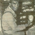 An African African man, a double amputee, works on a case of broken dolls.