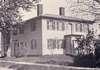A large house with a flat roof and two chimneys.