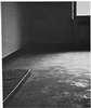 A thin mattress pad on a cement floor.