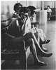 Women on a bench, one naked and tied.
