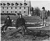 Three boys playing outside institution.