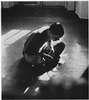 A boy sitting cross legged on the floor.