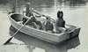 Photograph of young man helping a boy row a rowboat.  Two girls are also in the boat.