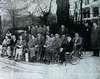A newspaper photograph of about twenty people, about half of whom are in wheelchairs.