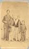 Chang and Eng stand between a young man and a boy.