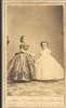 Two short-statured women, both formally dressed.