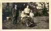 An elderly woman in a wheelchair with a boy and two men nearby.