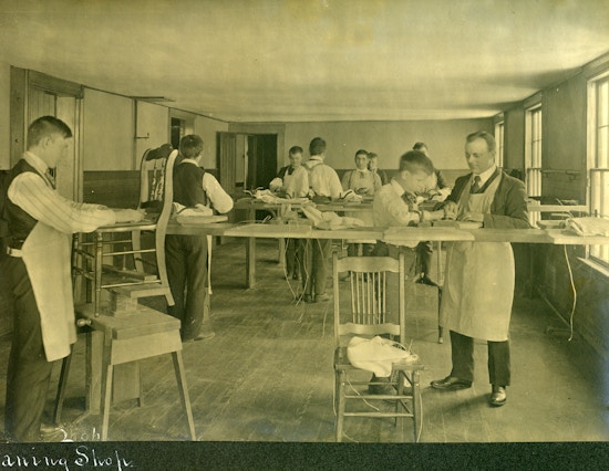 Shop with men and boys working on chairs.
