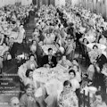Group photograph of International Congress on the Education of the Deaf attendees sitting at large round tables in a banquet room.