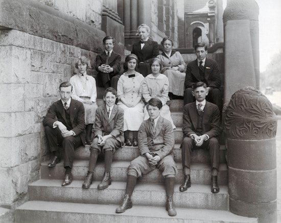 Group portrait of eleven people of which are students and possibly teachers of the Horace Mann School, seated on steps.