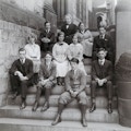 Group portrait of eleven people of which are students and possibly teachers of the Horace Mann School, seated on steps.