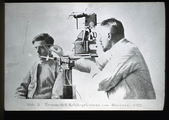 A doctor examining a patient's ear using an elaborate-looking diagnostic tool.