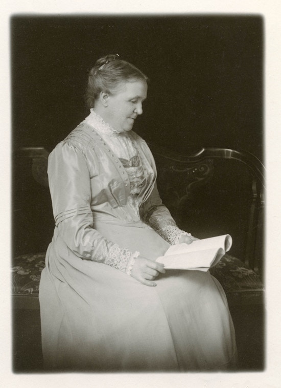 Srah Fuller seated, reading.