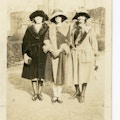 Three women, probably either teachers or alumni, standing arm in arm.