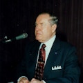 Jernigan at a sitting at a table in front of a microphone.