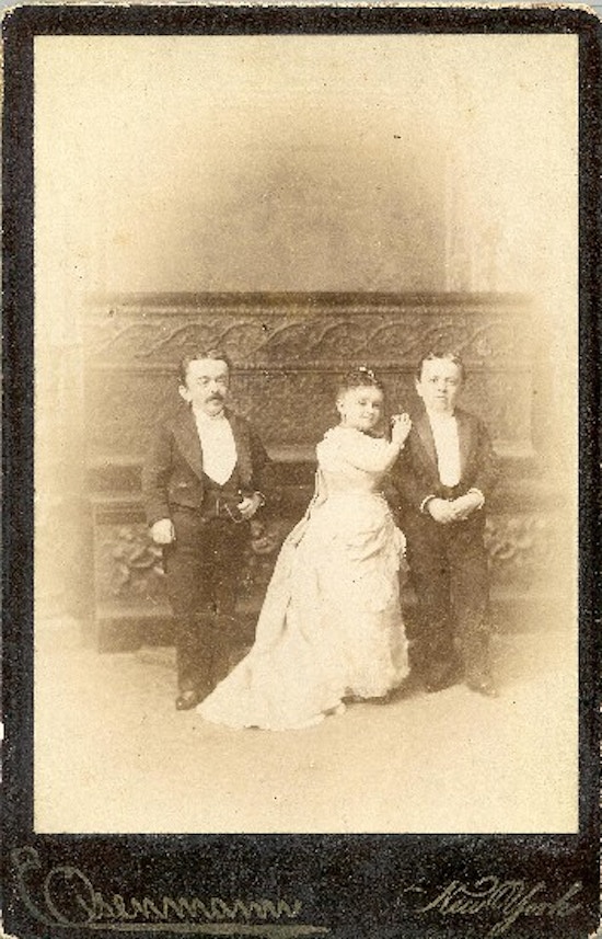 Two small-statured men with Minnie Warren between them.