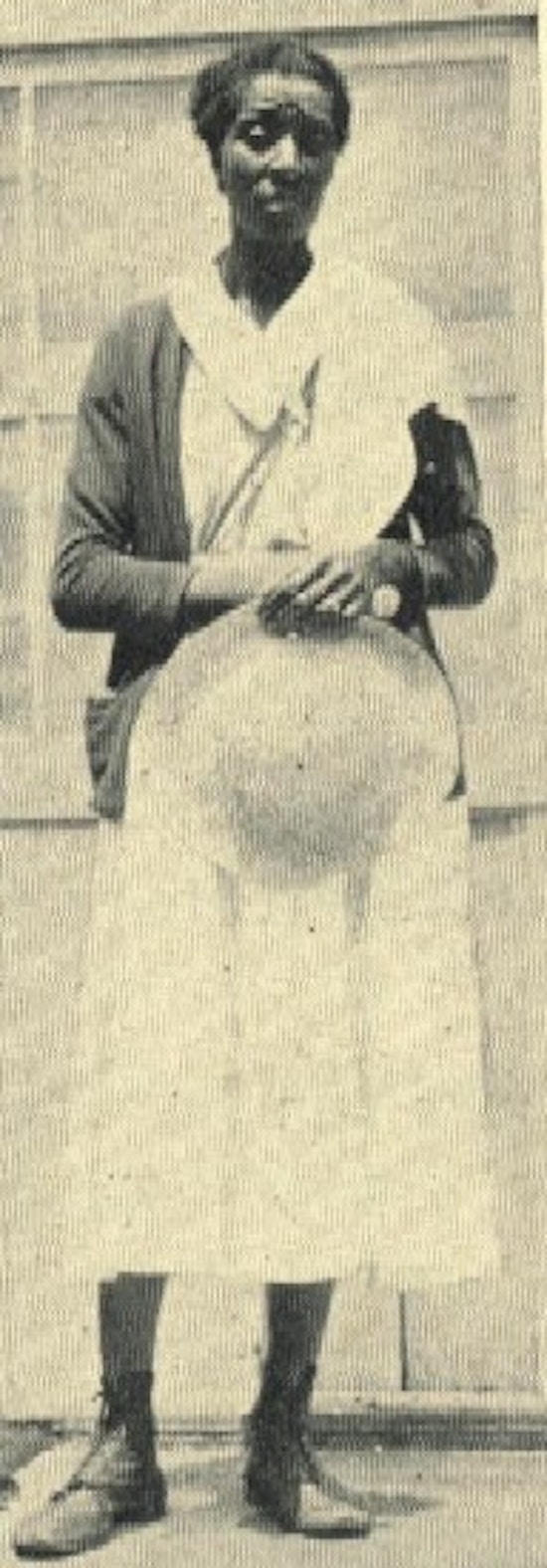 An African-American woman wearing a white dress.