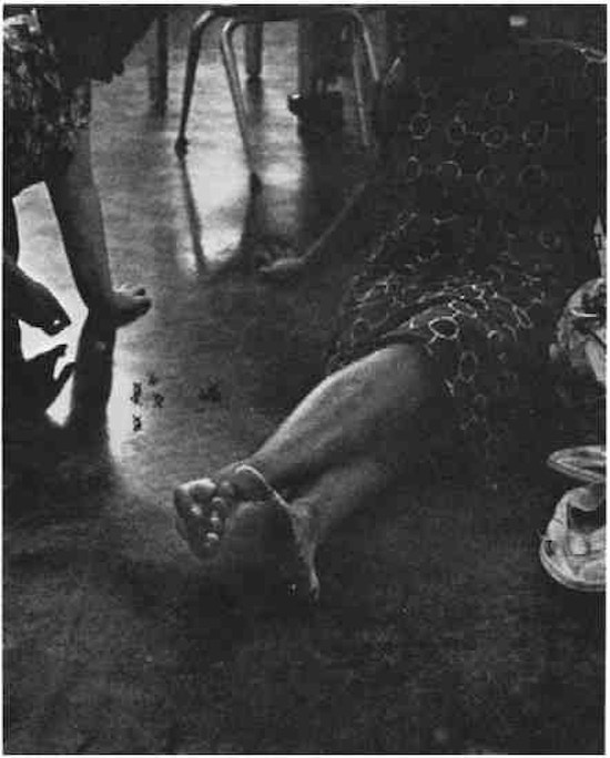 Women playing jacks on a tile floor.