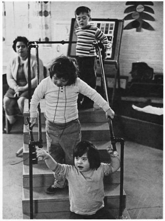 Children walking down stairs with handles.