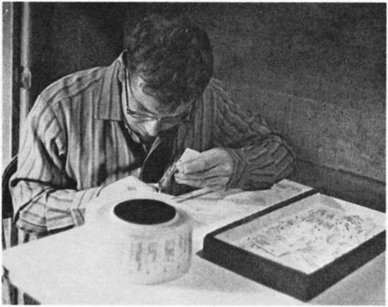 A young man cutting paper.