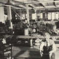 Men working in a shop repairing furniture.
