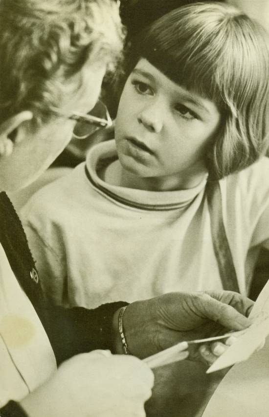 A boy with an elderly woman who holds scissors.