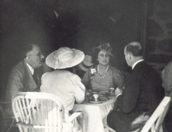 Franklin Roosevelt and the royal couple sit at a table on the porch of Top Cottage.